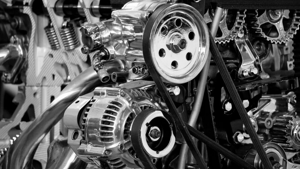 pexels photo 190574 Close-up of a shiny car engine showing polished metal parts and gears in black and white.
