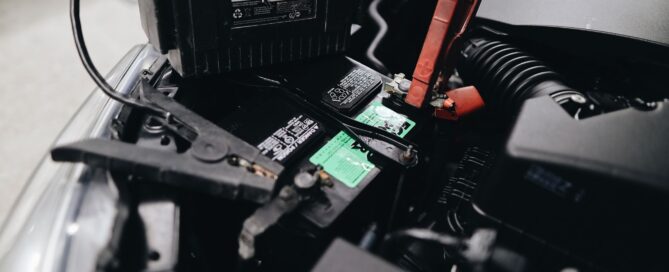 Jumper cables connected to a car battery in an engine bay